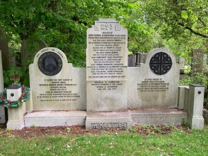 McKellar family gravestone in three sections, the left-hand section has a portrait of Archibald McKelllar and a wreath on a short pillar next to it